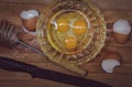 Top view of kitchen appliances and food. In a bowl of chicken eggs with yolks, next to the egg shell, knife, whisk for whipping