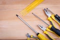 On a wooden background, a layout of pliers, screwdrivers and a ruler. Close-up. Top view. Royalty Free Stock Photo