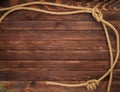 Wooden background made of dark brown boards with hemp ropes. Deck texture