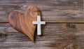 Wooden background with olive heart and white cross for an obituary notice. Royalty Free Stock Photo
