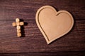 Wooden background with olive heart and white cross for an obituary notice. Royalty Free Stock Photo