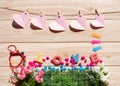 Wooden background with pink hearts,colored stone,bells,LOVE massage,arrow,white roses,pink roses,Green leaf.The concept of