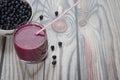 On a wooden background is a plate with blueberries and a glass with a diet drink blueberry smoothie. Place for Kopi Spey Royalty Free Stock Photo