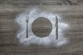 On a wooden background with powdered powder snow covered with silhouette plate fork knife appliances