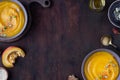 Wooden background, pumpkin soup in bowls, copy space