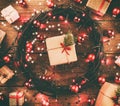 Wooden background with red lights and stars, surrounded by gifts and toys, in square shape, with effect. Royalty Free Stock Photo