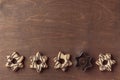 Wooden background with row of fresh baked homemade star-shaped cookie with chocolate and cutters, pattern Royalty Free Stock Photo