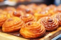 Wooden bakery display shelf filled with tasty bakery rolls close up