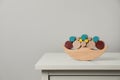 Wooden balance toy on chest of drawers near light grey wall, space for text. Children\'s development Royalty Free Stock Photo