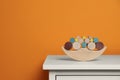 Wooden balance toy on white chest of drawers near orange wall, space for text. Children\'s development Royalty Free Stock Photo