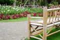 Wooden bamboo bench in flower garden Royalty Free Stock Photo