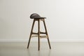 Wooden bar stool with a molded leather seat Royalty Free Stock Photo