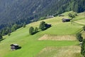 Wooden barns for hay at the slope of a mountain