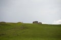 Wooden barns on the hill against the cloudy sky