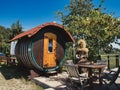 Wooden barrel house in a lush, green garden