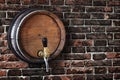 Wooden barrel with a tap in the old brick wall in grunge style Royalty Free Stock Photo