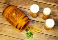 A wooden barrel, three different glasses of light beer, hops and ears of corn lie on a wooden table Royalty Free Stock Photo