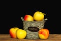 Wooden basket with fresh colorful apples on dark background Royalty Free Stock Photo