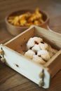 A wooden basket holding two delicious BBQ pork buns