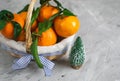 Wooden Basket Mandarine with Leaves and Lights, Tangerine Orange on Gray Table Background Christmas New Year Decors Royalty Free Stock Photo