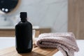 Wooden bath tray with shower gel and fresh towel on tub indoors Royalty Free Stock Photo