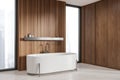 Wooden bathroom corner with white tub and windows Royalty Free Stock Photo