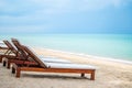 Wooden beach bed or sunbed beach with white cushion on beautiful beach with turquoise ocean and blue sky, perspective view with Royalty Free Stock Photo