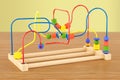 Wooden bead maze, educational toy on the wooden table. 3D render