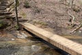 Wooden beam bridge over creek on forest trail Royalty Free Stock Photo