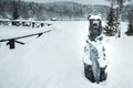 Wooden bear in the snow against the backdrop of a snowy forest and lake. Russian winter Royalty Free Stock Photo