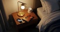Wooden bedside table with a modern lamp featuring a spherical bulb and a golden frame. Items Royalty Free Stock Photo