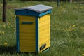 Wooden beehives for bees on green grass with yellow flowers. Old honey bee apiary. Spring countryside view Royalty Free Stock Photo