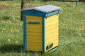 Wooden beehives for bees on green grass with yellow flowers. Old honey bee apiary. Spring countryside view Royalty Free Stock Photo