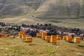 Wooden beehives sit in the sunshine on a hill above a mountain village in Georgia