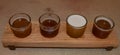 Wooden beer sampling tray with four brews