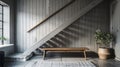 Wooden bench against grey wall and staircase.