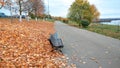 Wooden bench autumn in park, background golden leaves from trees, October September, rest walk the park. In distance Royalty Free Stock Photo