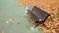 Wooden bench in the autumn in the park Side view., a background of golden leaves from the trees, in October September Royalty Free Stock Photo