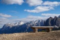 Wooden bench and in the background view of the mountain peaks. Belluno Province, Dolomiti Alps, Italy Royalty Free Stock Photo