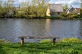 Wooden bench on the bank of the river. Spring landscape Royalty Free Stock Photo