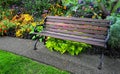 Wooden bench in beautiful colorful garden. Royalty Free Stock Photo
