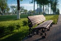 A wooden bench on a cobblestone path in a summer morning Park Royalty Free Stock Photo