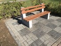 A wooden bench with concrete supports built in between the interlock floor tile flooring for a healthy and relax