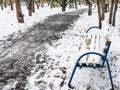 Wooden bench covered by the first snow in park Royalty Free Stock Photo