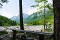 Wooden bench in the forest against the mountains. Royalty Free Stock Photo