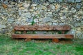 Wooden Bench in Front of a Rock Wall