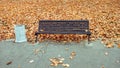 Wooden bench in front view autumn in the park, a background of golden leaves from the trees, in October September, rest Royalty Free Stock Photo