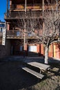 Wooden bench on a garden in front of a typical alpine touristic building