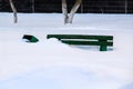 Wooden bench in winter under the snow, inaction of snow blowers in the snowfall