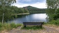 Wooden Bench On A Hill, Against The Backdrop Of A Picturesque Landscape, A Lake, Mountains And A Forest.